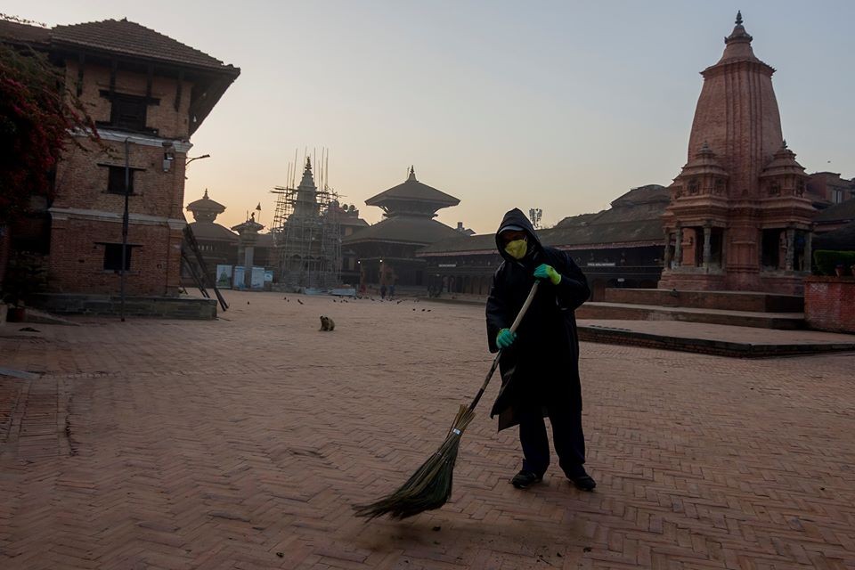 A worker wearing the protective dress cleaning the Bhaktapur Durbar Square area Picture by: Wave Magazine